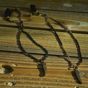 Gold Wing Charm Bracelets. One With Black Accents And One With Blue.